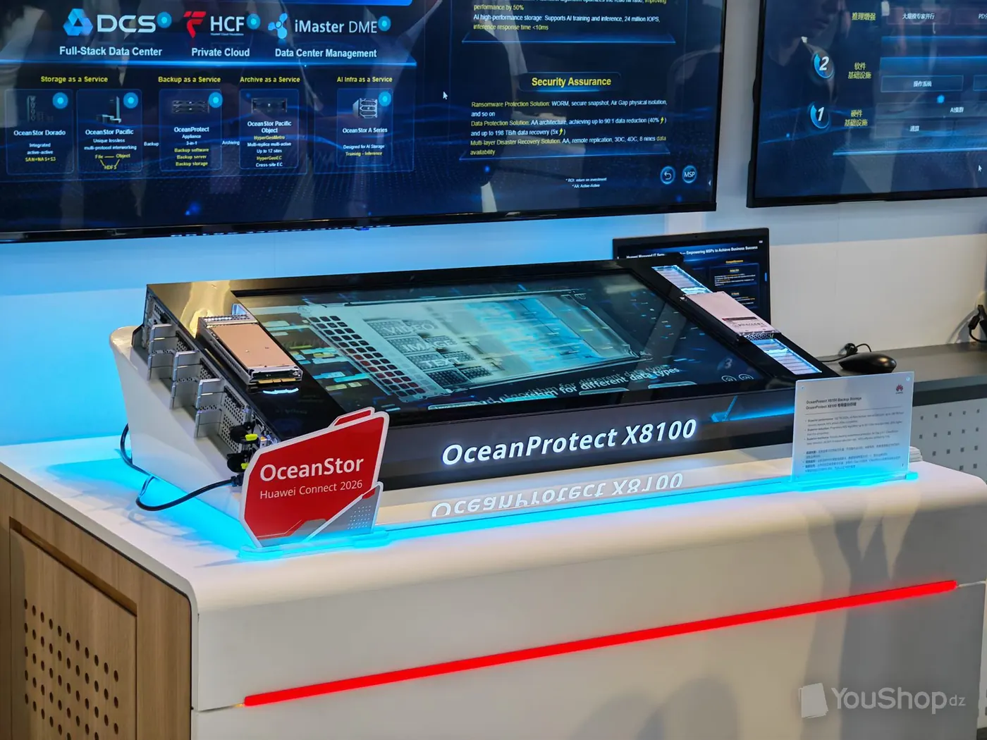 Châssis de sauvegarde Huawei OceanProtect X8100 exposé sur un pupitre sous deux écrans muraux