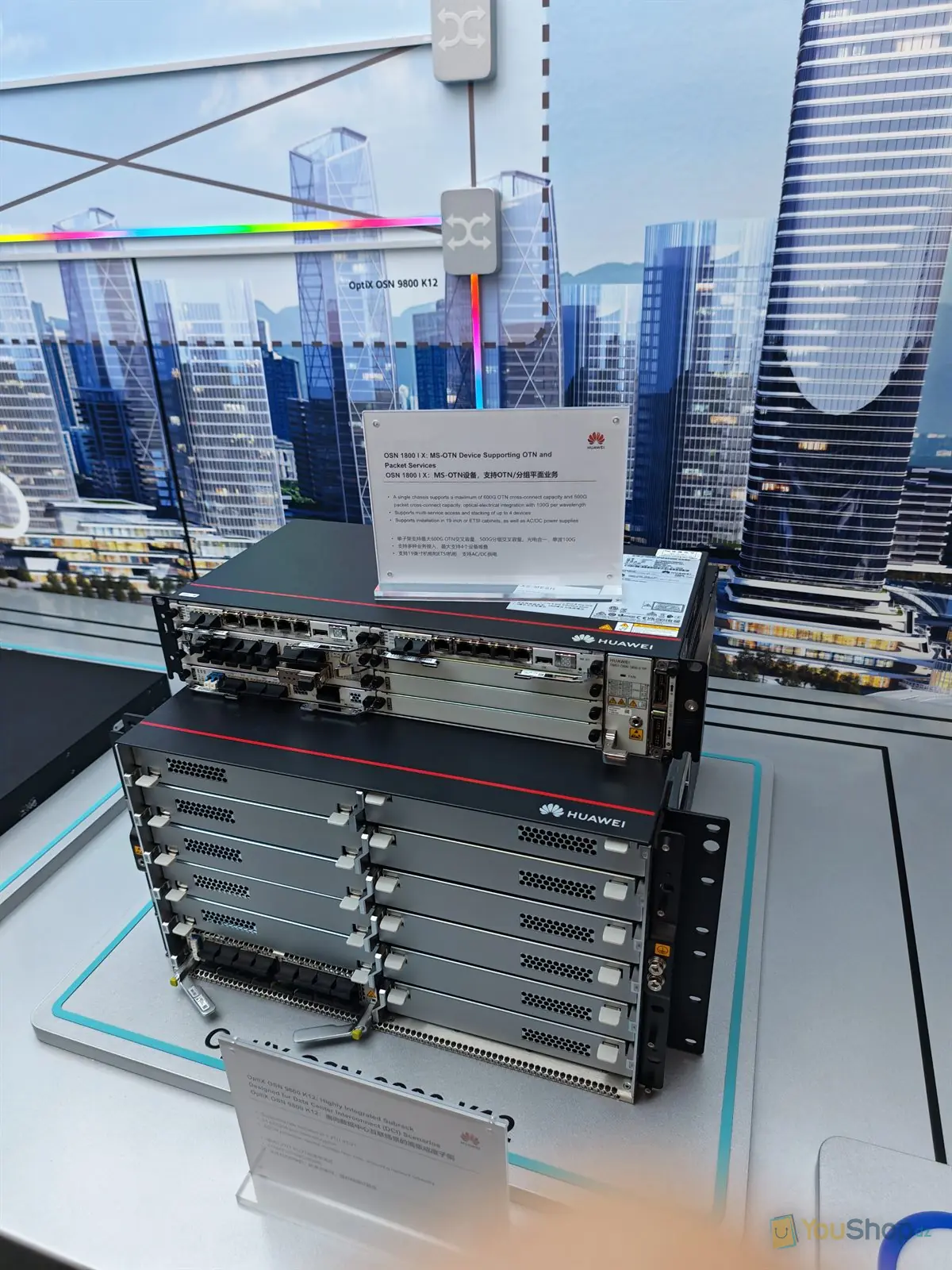 Deux châssis de transport optique Huawei empilés en vitrine devant un décor de gratte-ciel