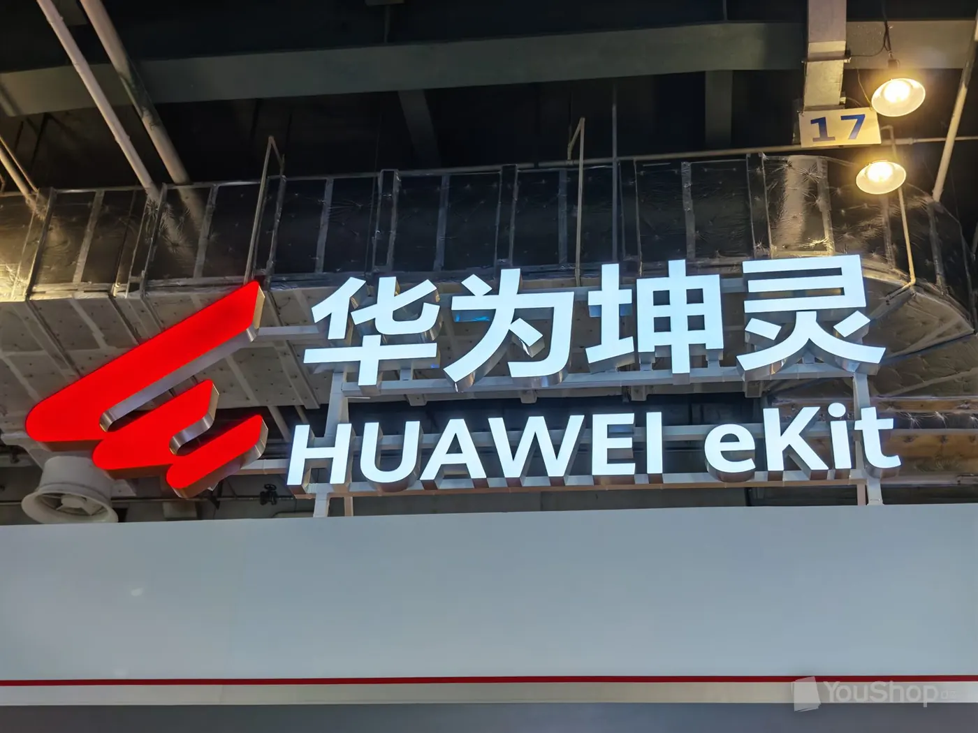 Enseigne lumineuse HUAWEI eKit et caractères chinois 华为坤灵 sous la charpente du hall