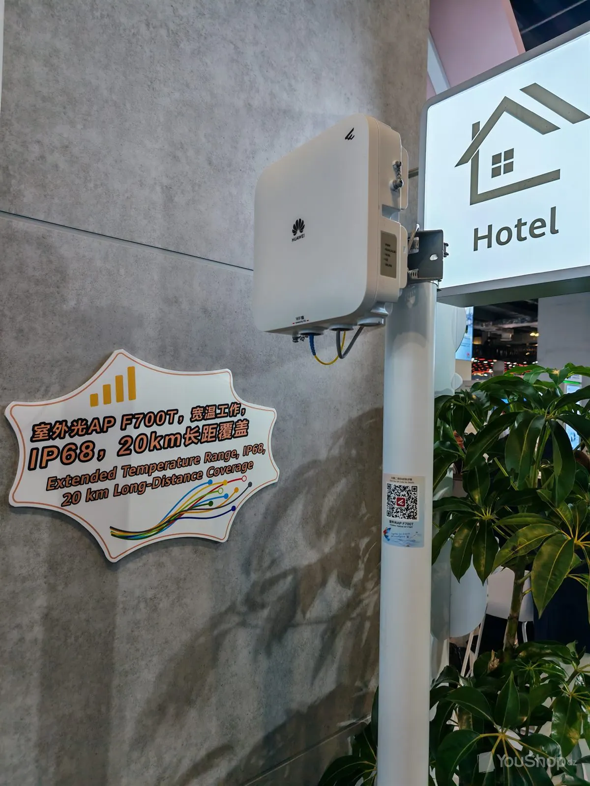 Point d'accès optique extérieur Huawei F700T fixé sur un mât blanc, sous un panneau lumineux Hotel